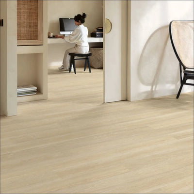 Light-colored quickstep eligna laminate flooring in estate oak beige with smooth wood-effect finish