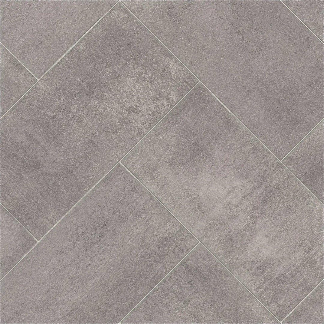 Gray concrete-effect caspien sheet vinyl flooring tiles arranged in a herringbone pattern with felt backed finish