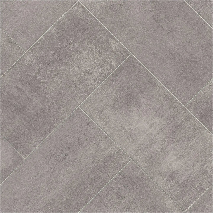 Gray concrete-effect caspien sheet vinyl flooring tiles arranged in a herringbone pattern with felt backed finish