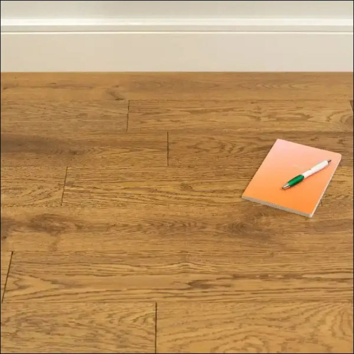 Orange sticky note pad with green and white pen on top for oxford golden brushed lacquered wood flooring product display