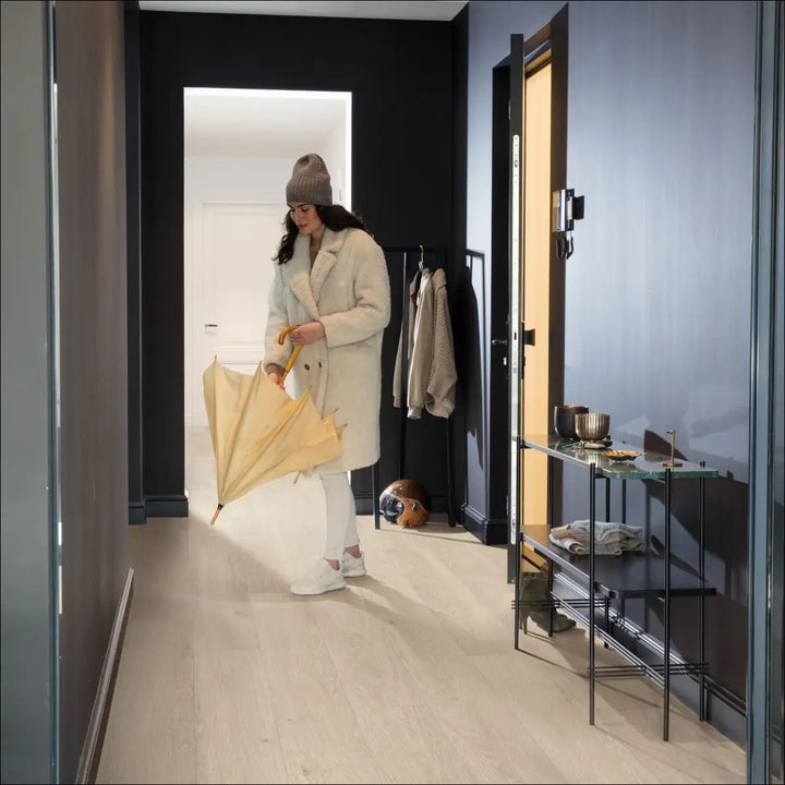 Quick Step Bloom Sea Breeze Oak Beige Luxury Vinyl Flooring AVMPU40080 Hallway with Lady Putting up Umbrella