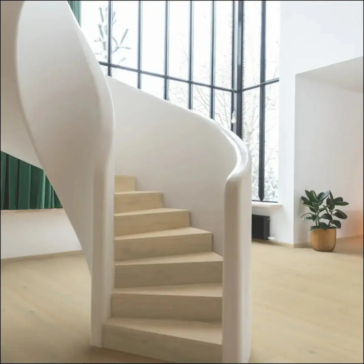 A sleek modern spiral staircase with smooth white railings and wintry forest oak quick-step cala light beige steps