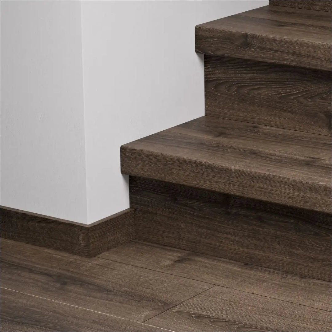 Dark brown quick-step capture stair covers with natural wood grain stair nosing and matching floor baseboard