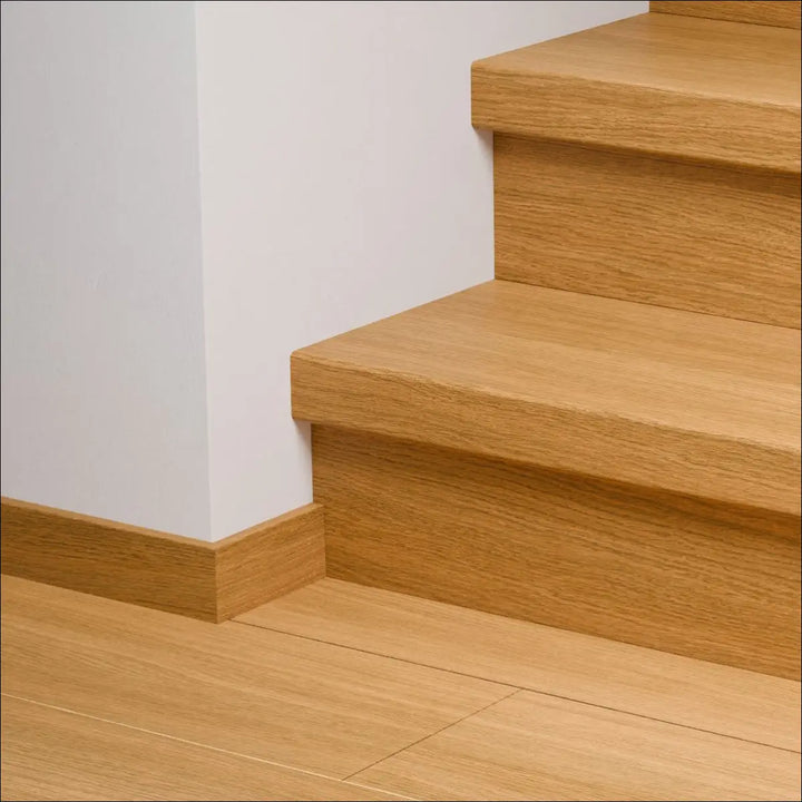 Light oak quick-step capture stair cover with matching baseboard and flooring featuring capture stair covers and stair nosing