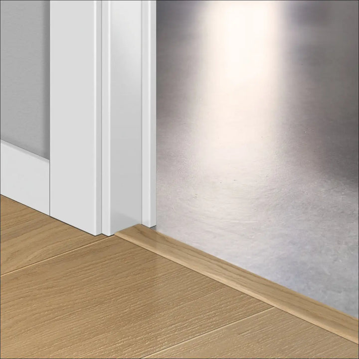 Light-colored wooden quick-step cascada incizo profile door threshold with smooth natural grain stair nosing finish
