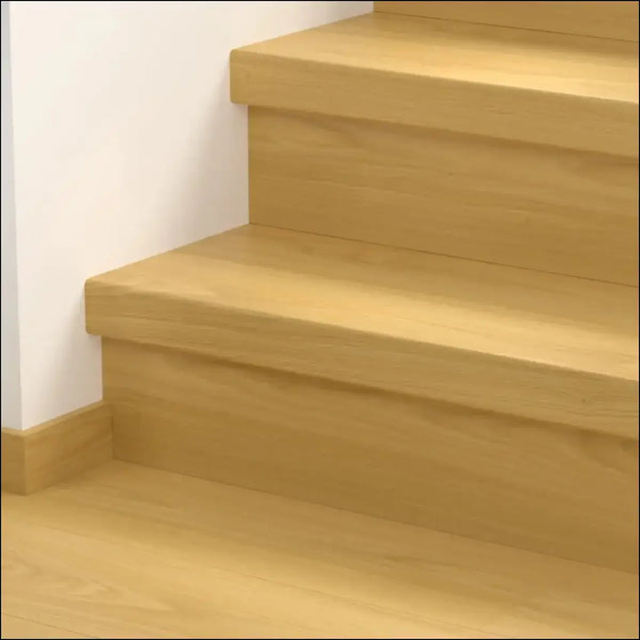 Light oak wooden stairs with a smooth minimalist design covered by quick step classic stair cover laminate flooring