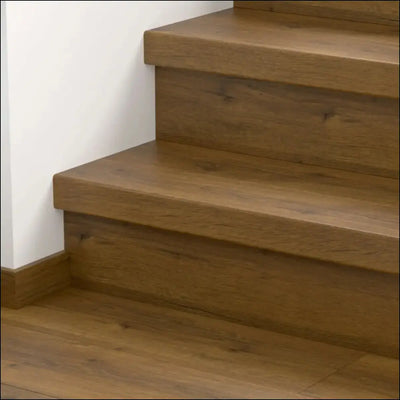 Modern wooden staircase with warm medium brown finish and visible grain featuring quick step classic stair cover