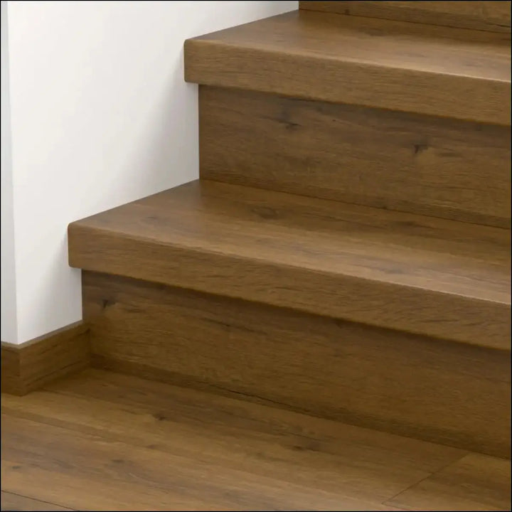 Modern wooden staircase with warm medium brown finish and visible grain featuring quick step classic stair cover