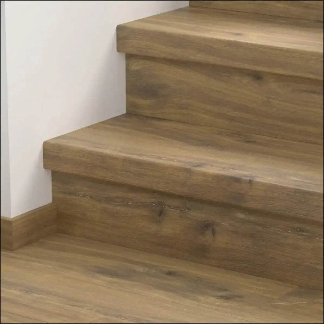 Quick step classic stair cover with light brown natural wood grain finish and visible knots on a wooden staircase