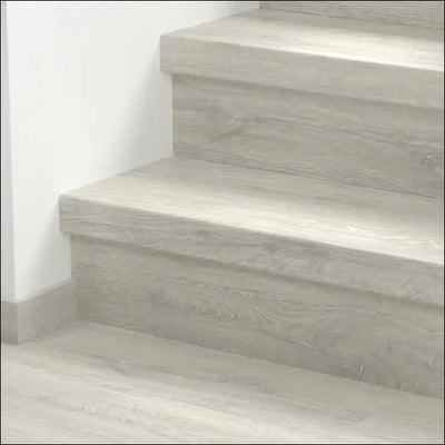 Gray wood grain textured staircase steps covered with quick step classic stair cover in classic laminate flooring style