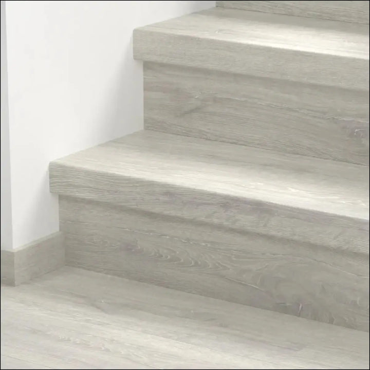 Gray wood grain textured staircase steps covered with quick step classic stair cover in classic laminate flooring style