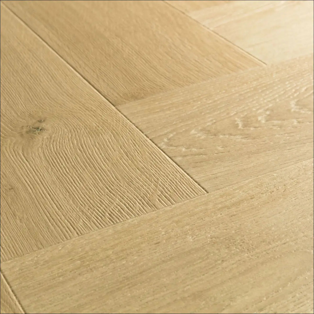 Light oak hardwood flooring with herringbone pattern and visible grain in quick step impressive design cardamom oak imd8242 with scratch guard