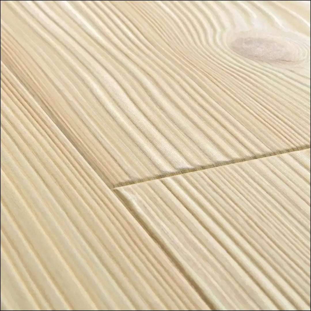 Light-colored quick step impressive laminate natural pine floor planks with natural grain and visible knot pattern