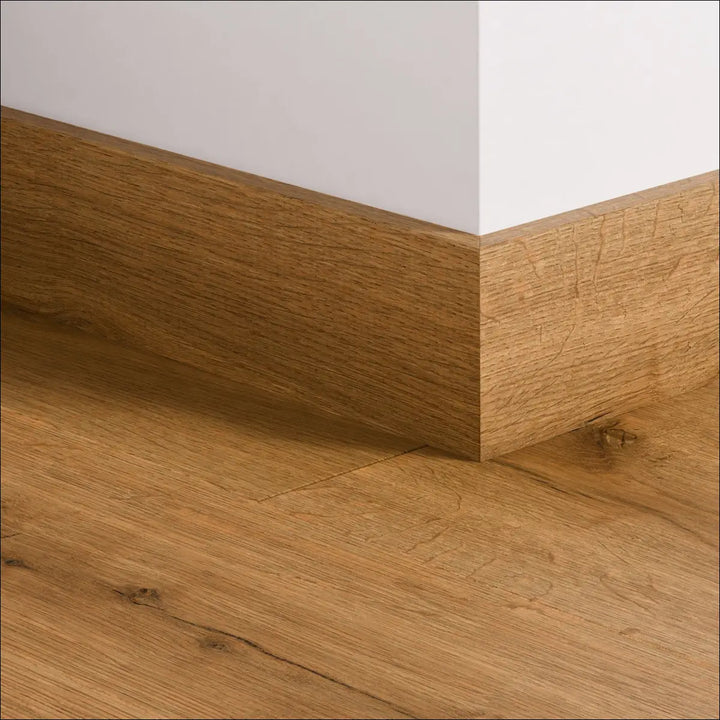 Natural oak wood quickstep impressive 77mm skirting board with warm medium brown finish and visible grain pattern