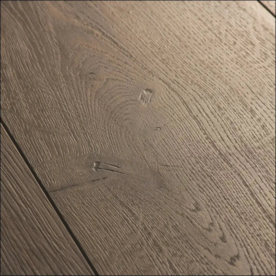 Grayish-brown quickstep capture laminate brushed oak flooring with natural textured grain and visible knots