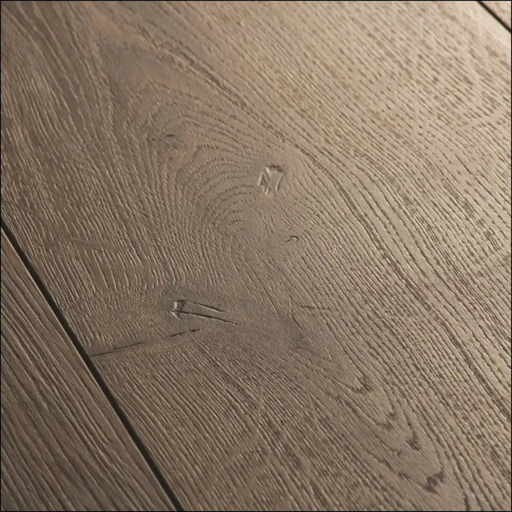Grayish-brown quickstep capture laminate brushed oak flooring with natural textured grain and visible knots