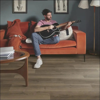 Black acoustic guitar with white pickguard and natural wood fretboard in quick-step capture laminate brushed oak brown finish