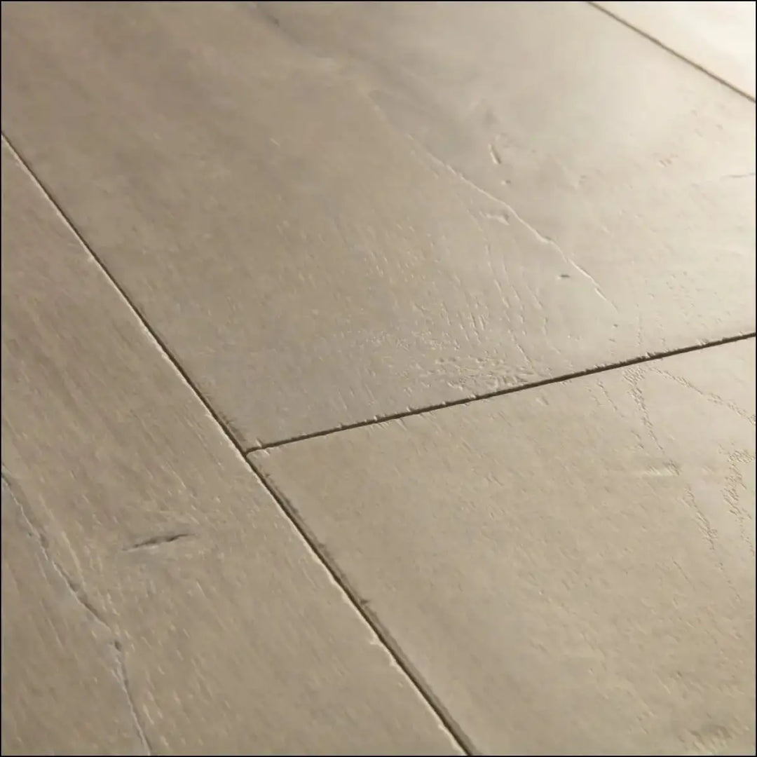 Beige stone effect floor tiles with subtle veining and matte finish in quickstep capture laminate patina oak brown