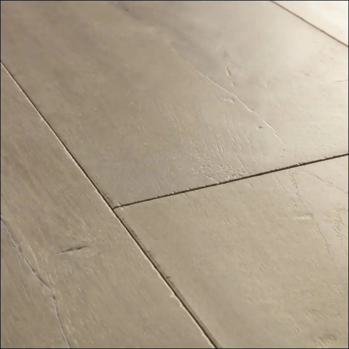 Beige stone effect floor tiles with subtle veining and matte finish in quickstep capture laminate patina oak brown