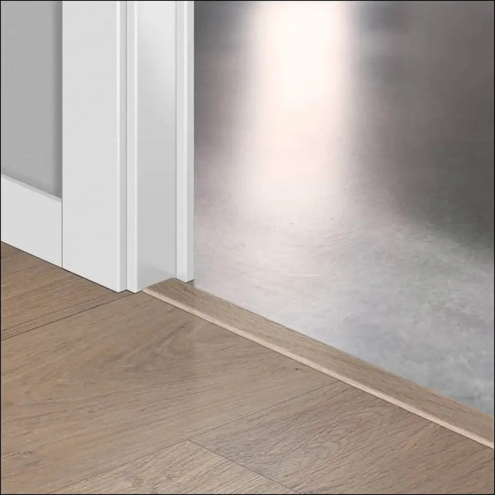 Light-colored wooden baseboard trim with quickstep classic incizo profile for a clean multi-use profile finish