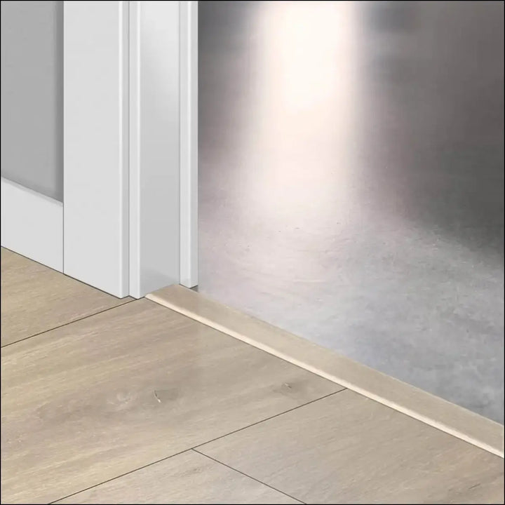 Light beige wooden floor trim with incizo profile from quickstep classic multi use profile along white door frame