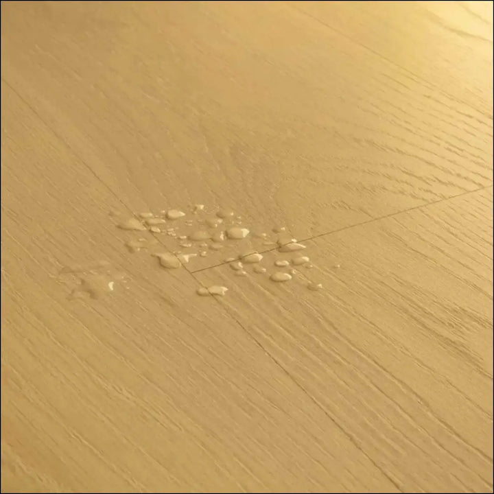 Light brown biscuit brown oak quick-step classic laminate flooring clm5794 with visible grain and water droplets on planks