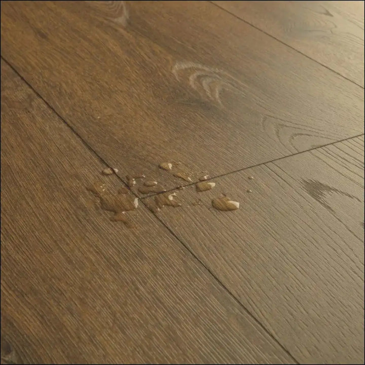 Dark brown hardwood floor with natural wood grain and plank seams in quickstep classic cocoa brown oak laminate clm5793