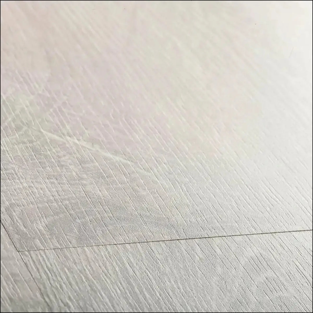 Light gray wood grain quickstep classic laminate flooring in reclaimed white patina oak with subtle matte finish