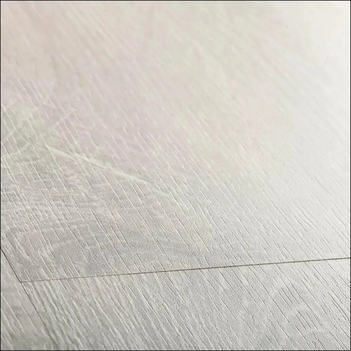 Light gray wood grain quickstep classic laminate flooring in reclaimed white patina oak with subtle matte finish