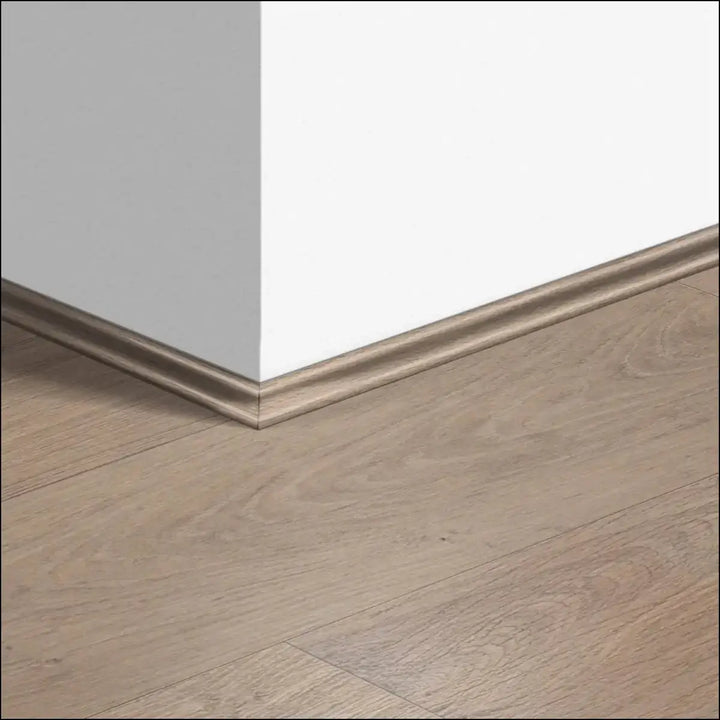 Beige wood-grain quickstep classic scotia beading with a smooth raised profile along the wall floor junction for quick-step flooring