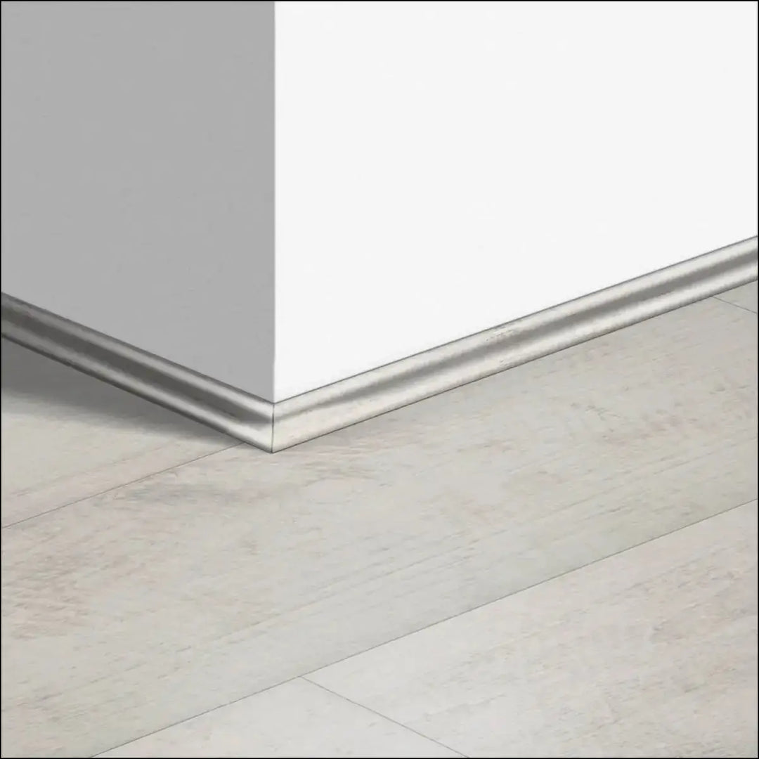 Silver metallic quickstep classic scotia beading baseboard trim along white wall and light quick-step flooring corner