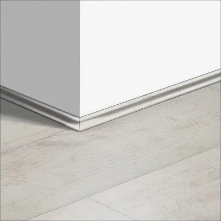 Silver metallic quickstep classic scotia beading baseboard trim along white wall and light quick-step flooring corner