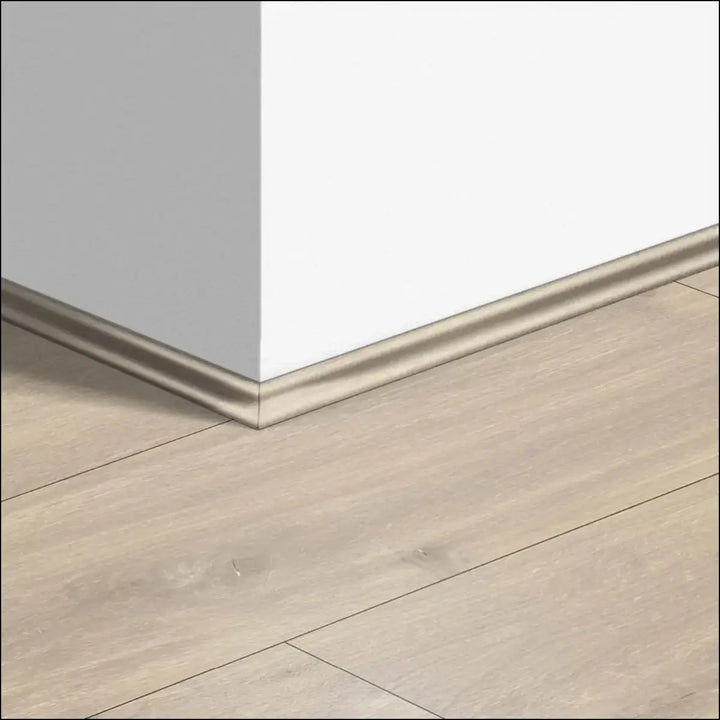 Beige wood-effect quickstep classic scotia beading on laminate floorboard with sleek modern profile along wall corner