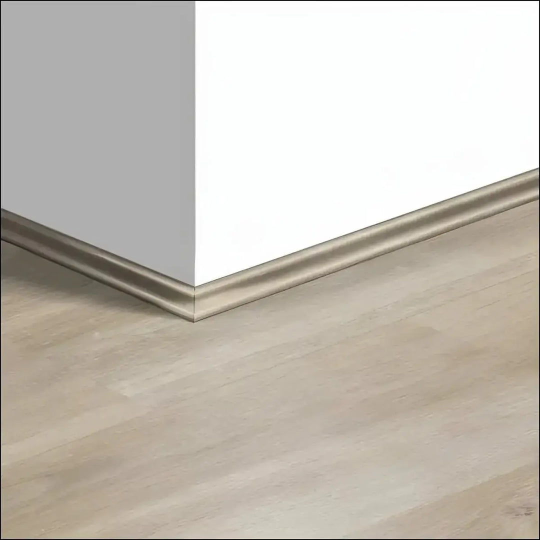 Silver metallic quickstep creo scotia baseboard trim along white wall and light wood quickstep creo flooring corner