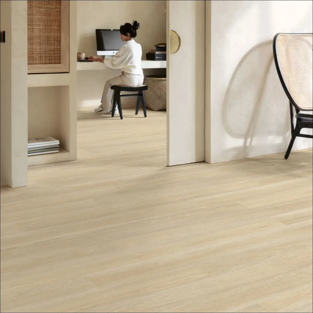Light-colored quickstep eligna laminate flooring in estate oak beige with smooth wood-effect finish