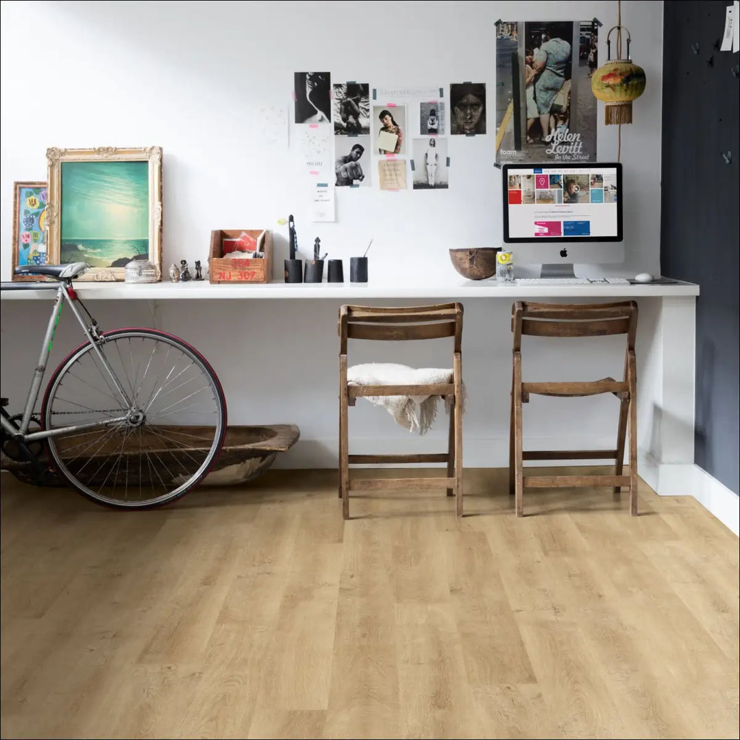 A sleek white desk on quickstep eligna laminate flooring venice oak natural with built-in monitor and decor items