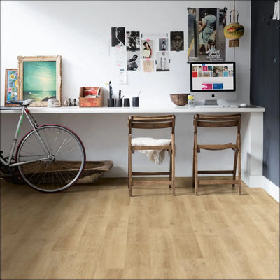 A sleek white desk on quickstep eligna laminate flooring venice oak natural with built-in monitor and decor items