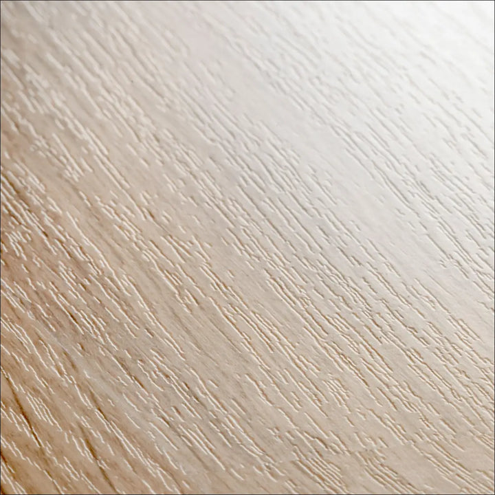 Light-colored quickstep eligna laminate flooring in white varnished oak with a subtle natural wooden grain pattern