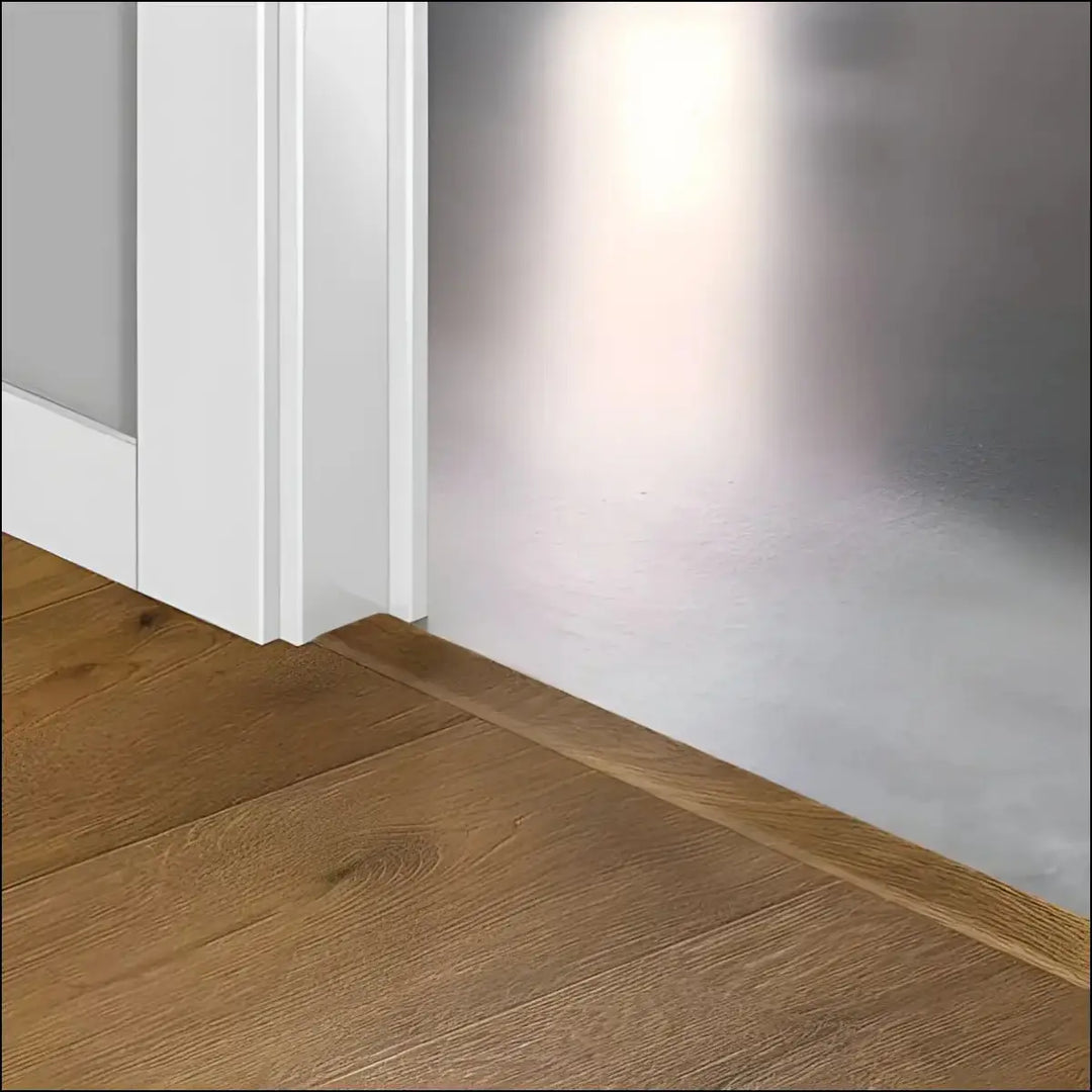 White door threshold with smooth edge and matching baseboard in quickstep intenso incizo profile flooring design