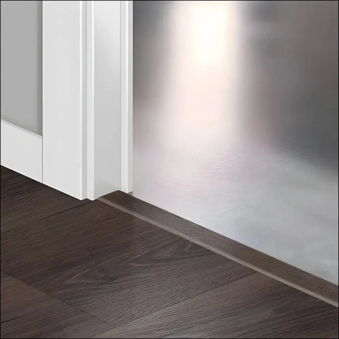 Dark brown wood grain floor trim at the base of a white door frame featuring quickstep majestic incizo profile