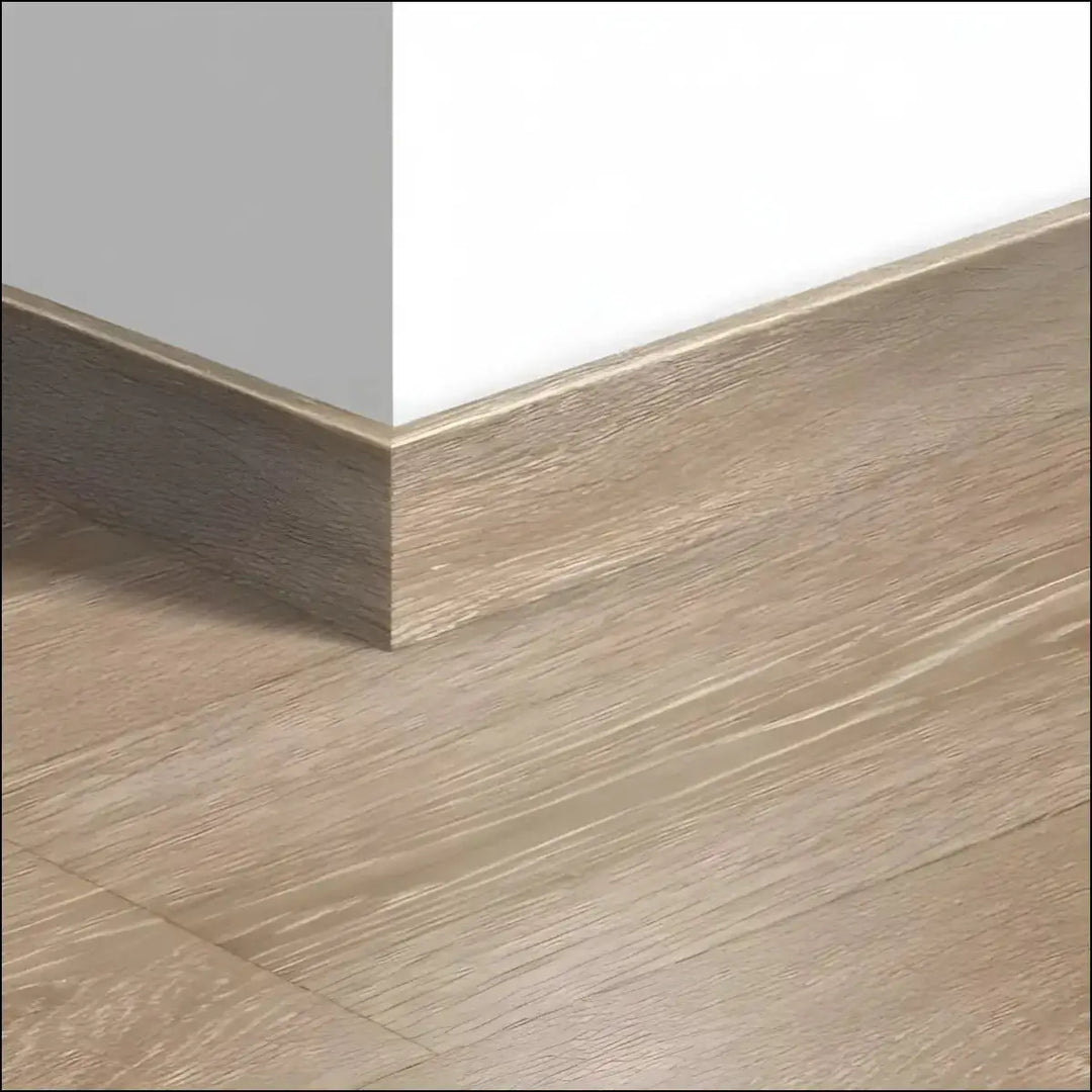 Light brown wood-grain laminate quickstep majestic skirting board with subtle metallic edge trim for matching skirting boards